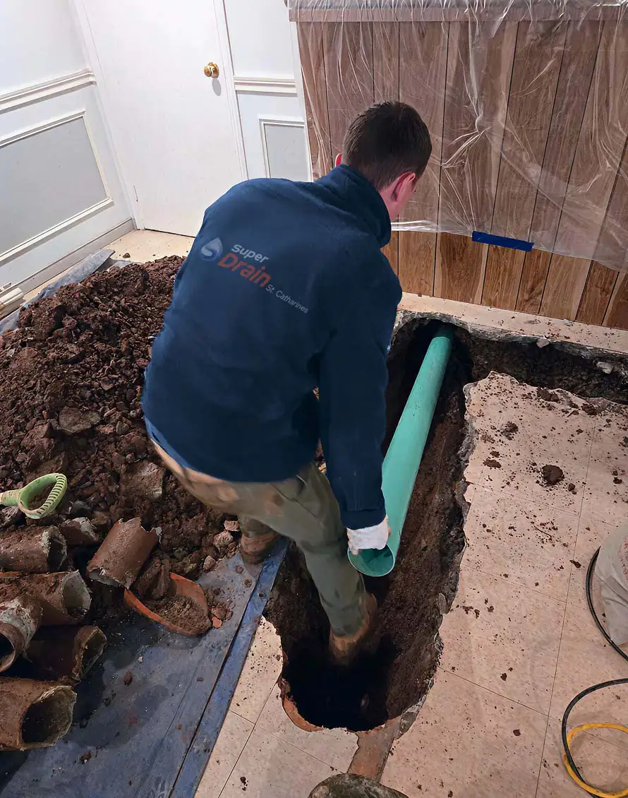 Plumber lays an underground pipe in a trench